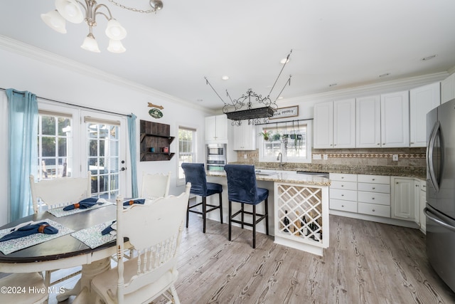 kitchen with a healthy amount of sunlight and white cabinetry