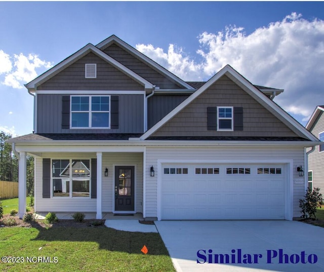 craftsman house with a front lawn, a porch, and a garage