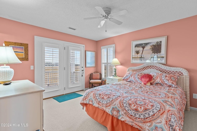 carpeted bedroom with a textured ceiling, access to outside, and ceiling fan