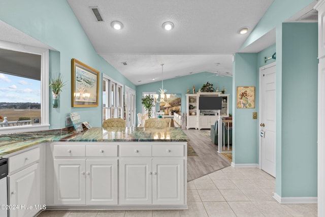 kitchen featuring white cabinetry, light tile patterned floors, hanging light fixtures, and vaulted ceiling