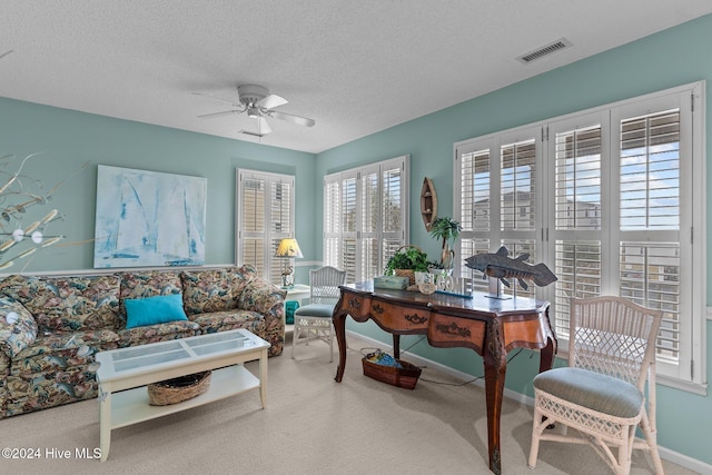 living room featuring ceiling fan, carpet floors, and a textured ceiling