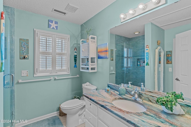 bathroom with vanity, a textured ceiling, toilet, and walk in shower