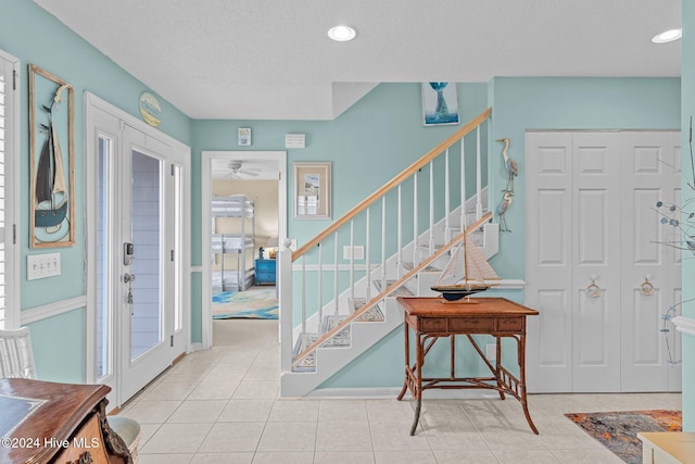 entryway featuring light tile patterned floors and a textured ceiling