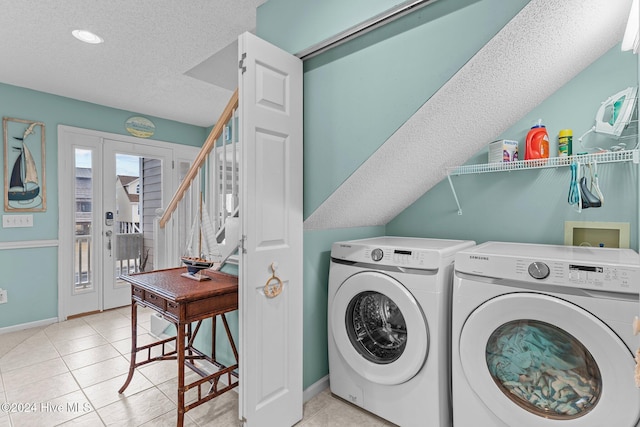 washroom featuring independent washer and dryer, a textured ceiling, and light tile patterned floors