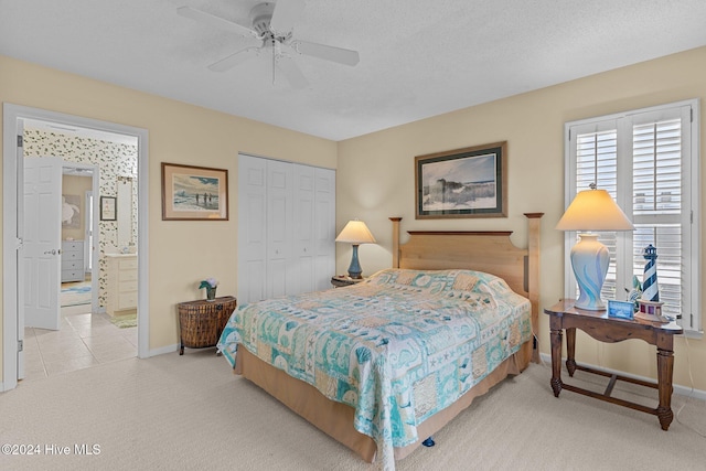 carpeted bedroom with ceiling fan, a closet, and a textured ceiling