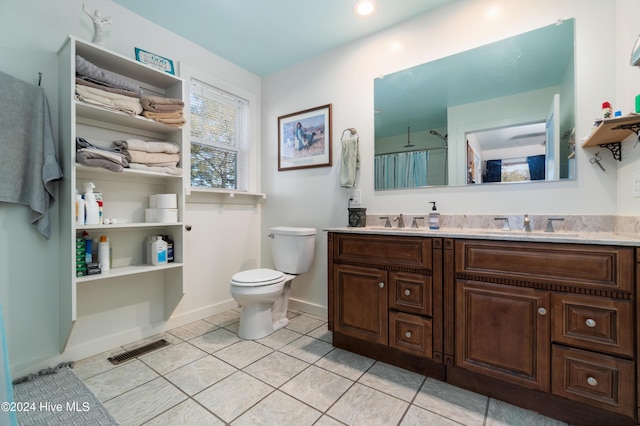 bathroom with tile patterned flooring, vanity, and toilet