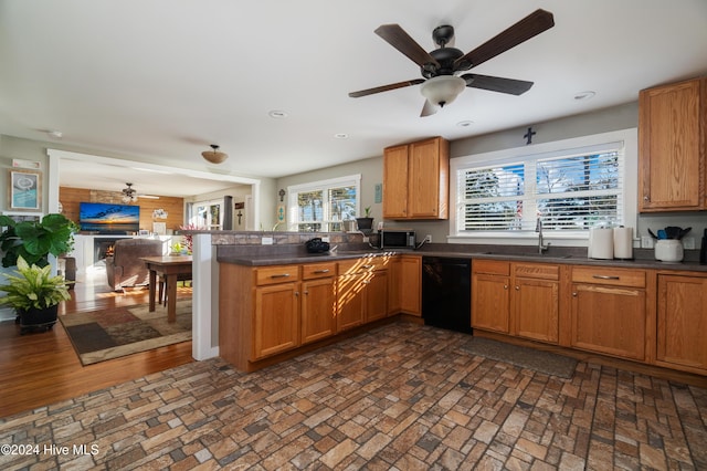 kitchen with sink, kitchen peninsula, black dishwasher, and a wealth of natural light