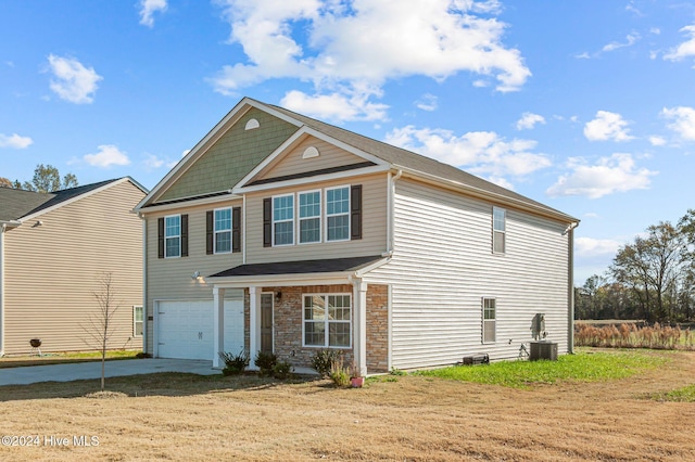 view of front of home featuring central AC unit, a front lawn, and a garage