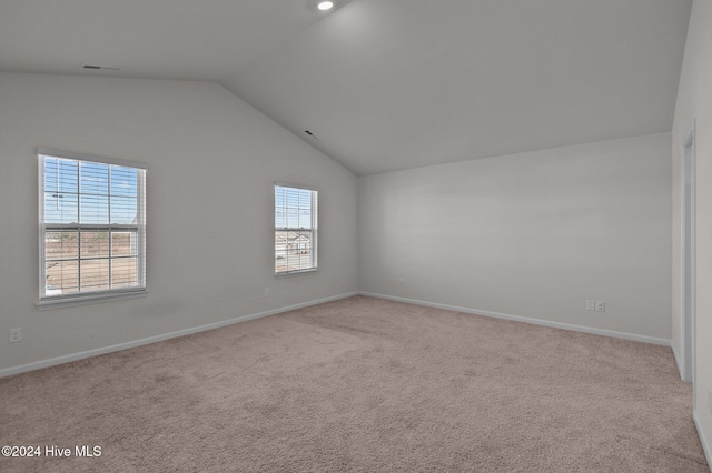 unfurnished room featuring light carpet and lofted ceiling