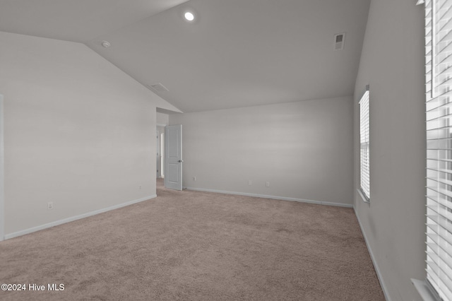 empty room featuring light carpet and lofted ceiling