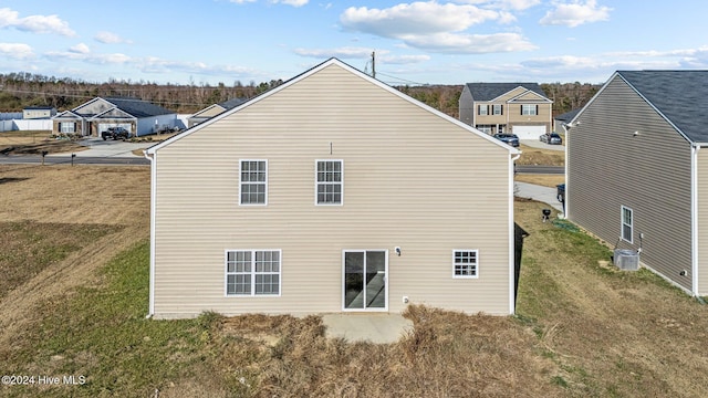 back of property with a lawn and central air condition unit