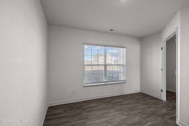 spare room featuring dark wood-type flooring