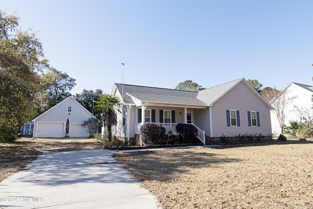 view of front of property featuring a porch, a garage, and an outdoor structure