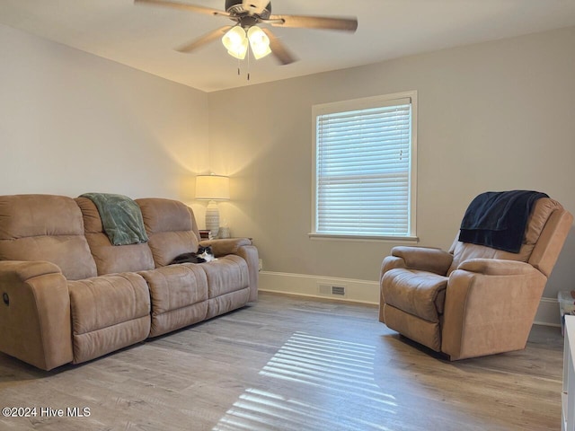 living room featuring light hardwood / wood-style floors and ceiling fan