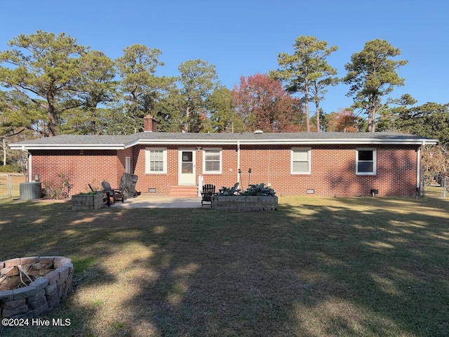 back of property featuring a fire pit, cooling unit, a patio area, and a lawn