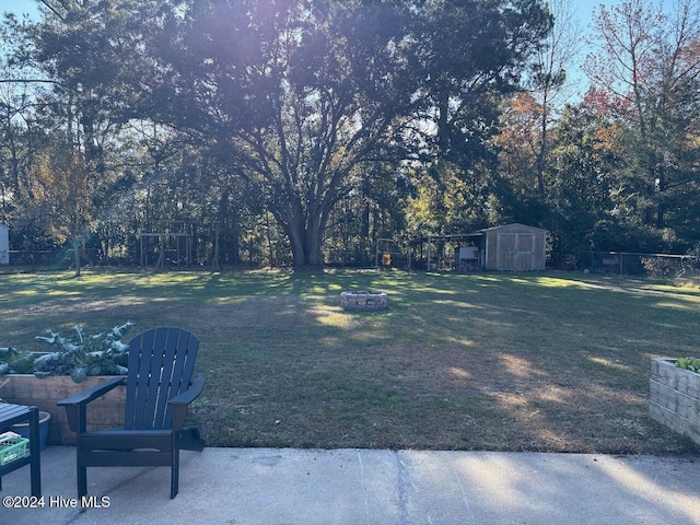 view of yard featuring a shed and an outdoor fire pit