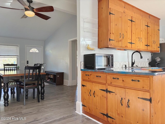 kitchen featuring ceiling fan, sink, wood-type flooring, beam ceiling, and high vaulted ceiling