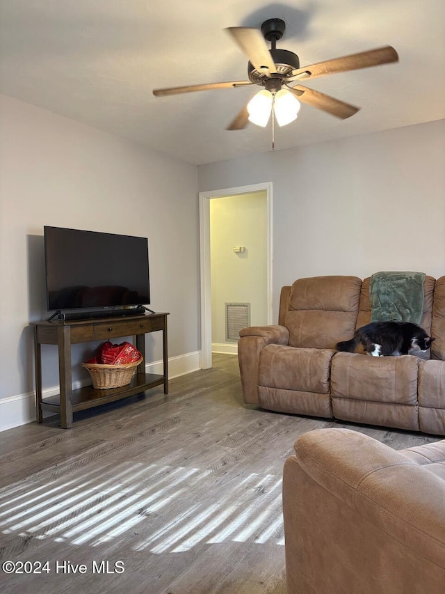 living room featuring hardwood / wood-style floors and ceiling fan