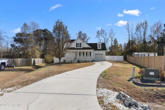 cape cod-style house with covered porch, a garage, and a front yard