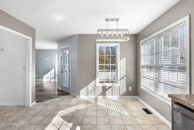 unfurnished dining area with light tile patterned floors and french doors