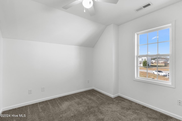 bonus room featuring dark colored carpet, a wealth of natural light, lofted ceiling, and ceiling fan