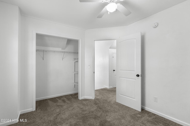 unfurnished bedroom with ceiling fan, a closet, and dark colored carpet