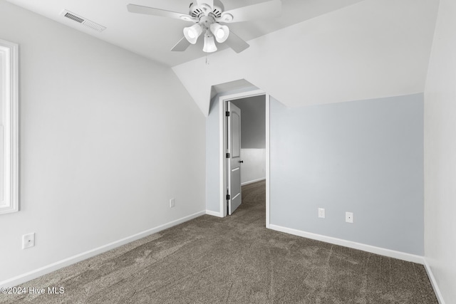 additional living space featuring dark colored carpet, ceiling fan, and lofted ceiling