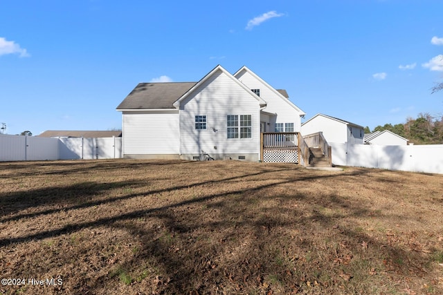 back of property featuring a deck and a yard