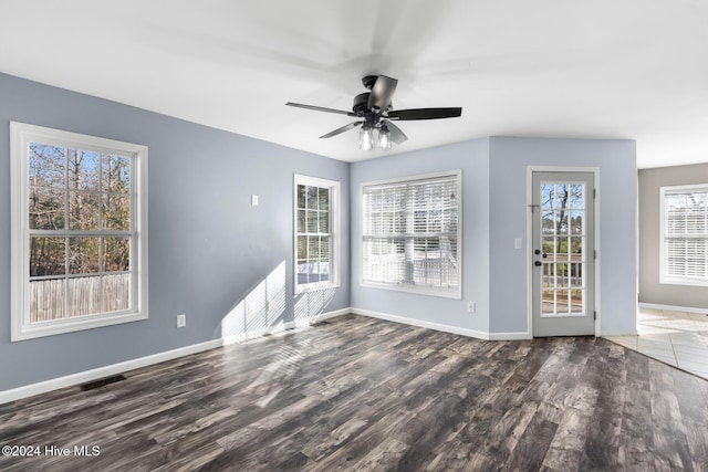 empty room with ceiling fan and dark wood-type flooring