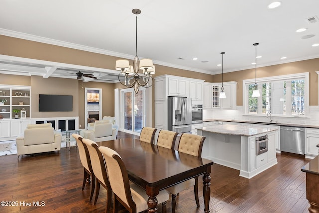 dining space with coffered ceiling, dark wood-type flooring, ornamental molding, ceiling fan with notable chandelier, and beamed ceiling