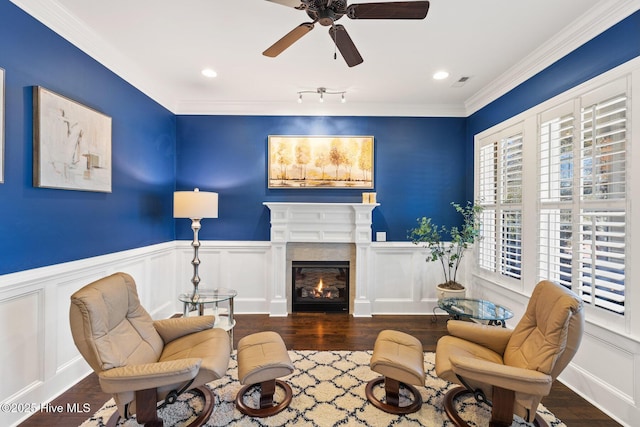 living area featuring ceiling fan, track lighting, dark hardwood / wood-style flooring, and ornamental molding