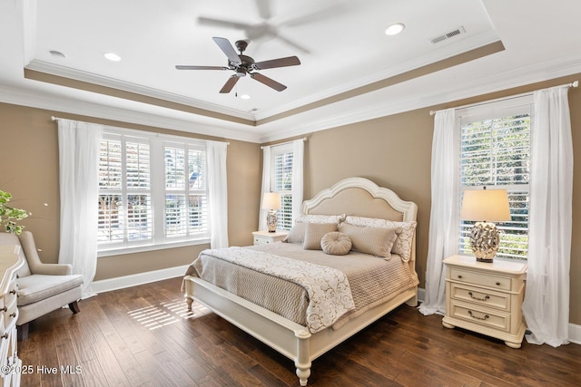 bedroom featuring ceiling fan, dark wood-type flooring, multiple windows, and a raised ceiling