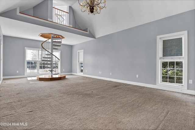 unfurnished living room featuring carpet, high vaulted ceiling, and an inviting chandelier