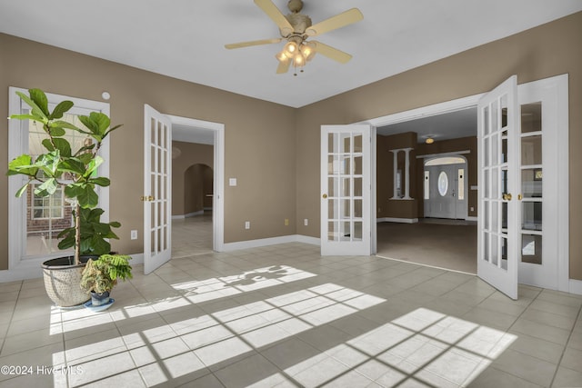 tiled spare room with ceiling fan and french doors