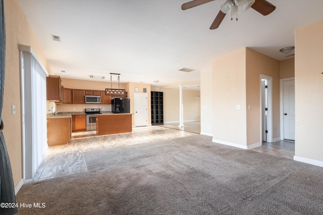 unfurnished living room featuring ceiling fan and light colored carpet