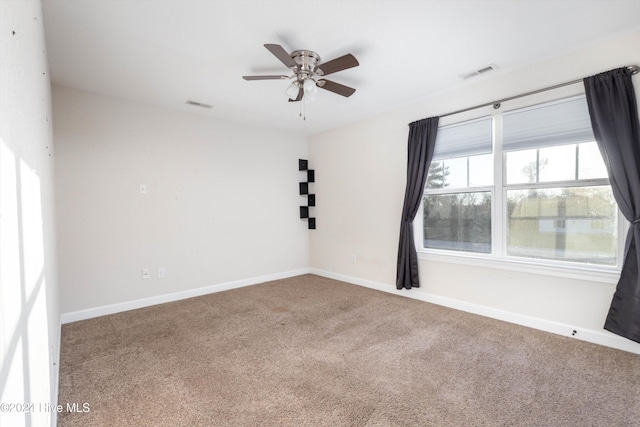 carpeted spare room featuring ceiling fan