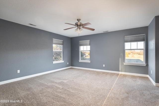 empty room featuring ceiling fan and carpet