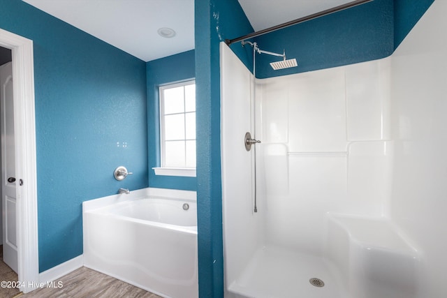 bathroom featuring wood-type flooring and shower with separate bathtub