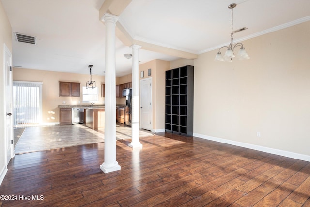 unfurnished living room featuring dark hardwood / wood-style floors, sink, an inviting chandelier, and ornamental molding