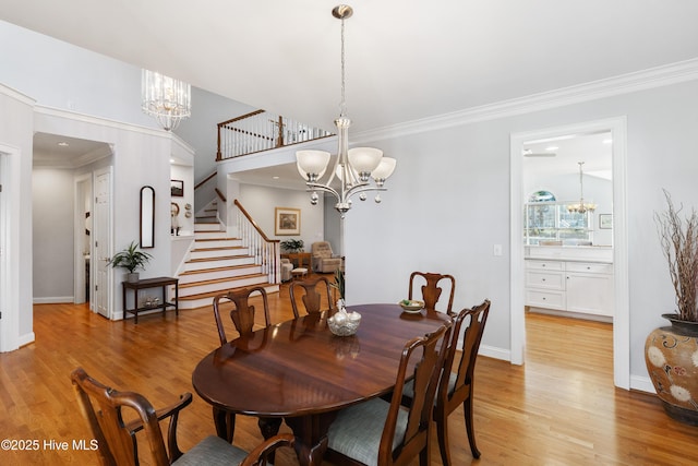 dining space with light wood-type flooring and ornamental molding