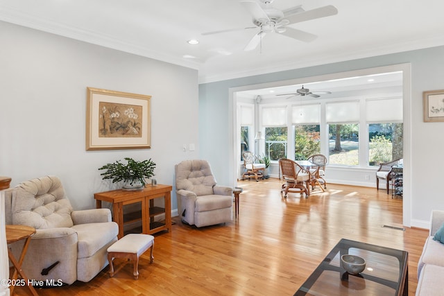 living room with crown molding, ceiling fan, and light wood-type flooring