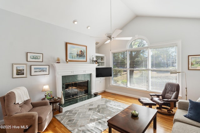 living room with ceiling fan, lofted ceiling, and light hardwood / wood-style flooring