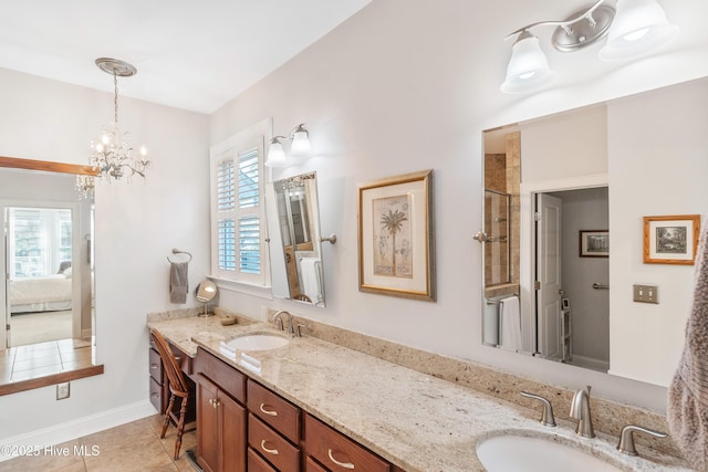 bathroom with tile patterned floors, vanity, a wealth of natural light, and a notable chandelier