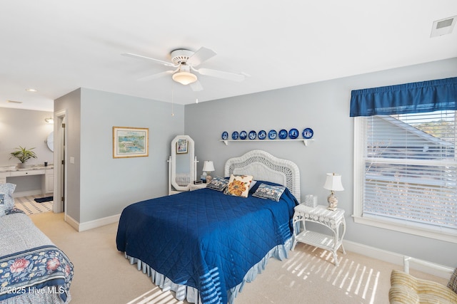 bedroom featuring ceiling fan, light carpet, and connected bathroom