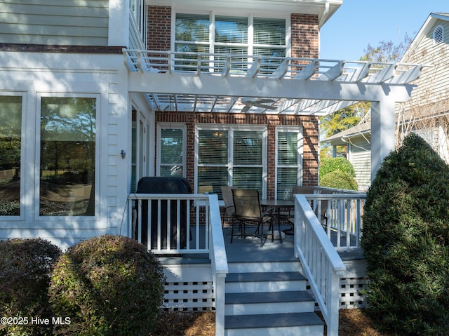 doorway to property featuring a pergola and a wooden deck