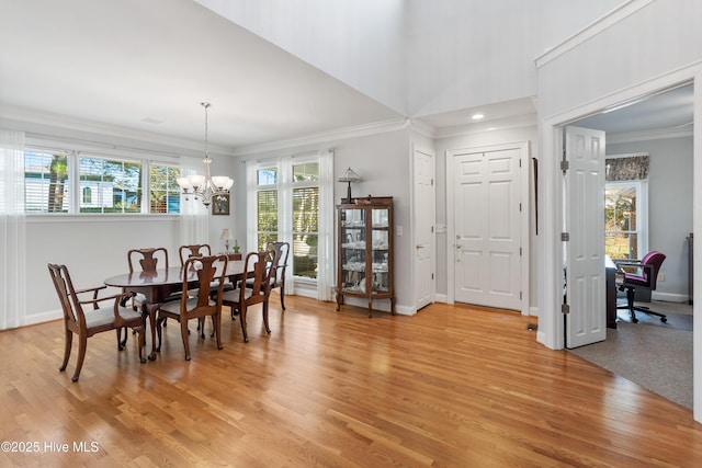 dining room featuring wood-type flooring, ornamental molding, and an inviting chandelier