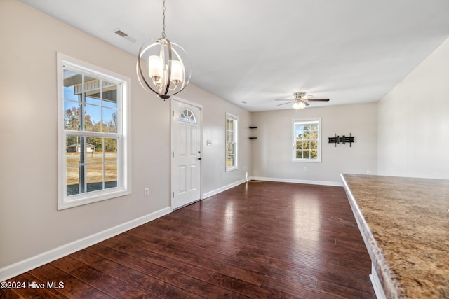 entrance foyer with dark hardwood / wood-style floors, a healthy amount of sunlight, and ceiling fan with notable chandelier