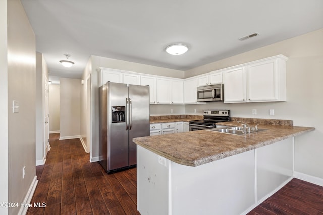 kitchen featuring white cabinets, appliances with stainless steel finishes, dark hardwood / wood-style flooring, and kitchen peninsula