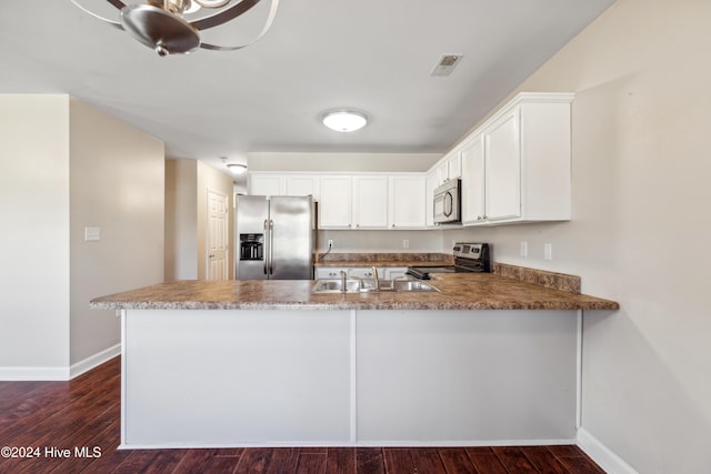 kitchen with white cabinets, dark hardwood / wood-style flooring, kitchen peninsula, and appliances with stainless steel finishes