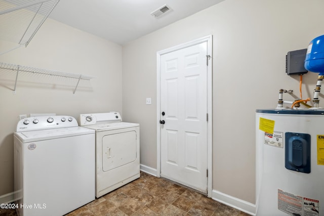 laundry room featuring washing machine and clothes dryer and water heater